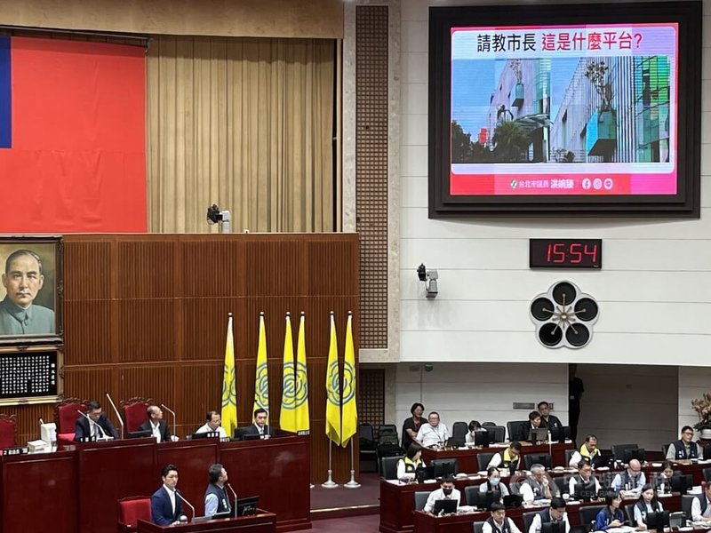 台北市議會13日召開第14屆第6次定期大會，民進黨市議員洪婉臻質詢時出示照片，質疑即將試營運的大巨蛋影城外牆平台的逃生緩降機被樹木盆栽淹沒。北市消防局隨即派人勘查，認為影城緩降機現場操作空間符合規定。中央社記者楊淑閔攝　114年10月13日