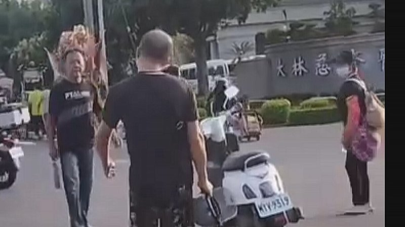 嘉義縣某宮廟繞境隊伍11日下午行經大林慈濟醫院旁時,突有一名酒醉男子(左)持刀混入隊伍中,意圖傷人。(民眾提供)中央社記者蔡智明傳真 114年10月14日