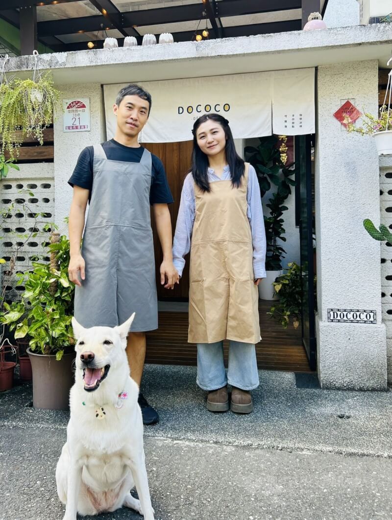 「逗可可甜點研究室」創辦人杜國維(左)和陳映儒(右)為實現與已逝愛犬的未竟之約,決心捨棄在台北打拚許久的根基搬回宜蘭創業。前為其再領養店狗「可可」。中央社記者林孟汝攝 114年10月16日
