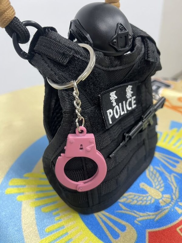 韓國女團BLACKPINK週末將在高雄開唱，小港警分局藉「粉紅旋風」宣導防詐推出抽獎活動，吸引民眾互動學習，還能抽附贈粉紅小手銬吊飾的警用防彈背心造型小杯套。（高雄市小港警分局提供）中央社記者洪學廣傳真  114年10月17日