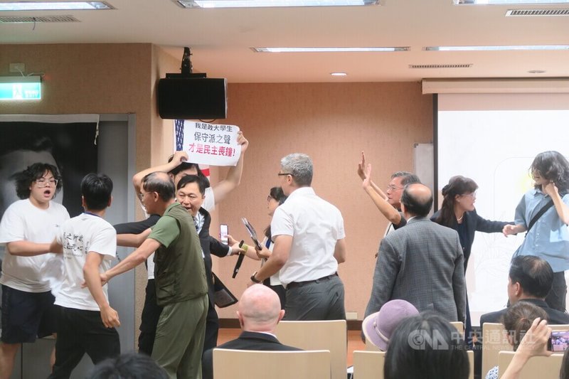福和會18日舉辦「愛、信念、勇氣-查理柯克紀念會」,一群自稱是台大、政大、師大與東吳大學的學生突然衝向台前高舉標語抗議。中央社記者吳書緯攝 114年10月18日