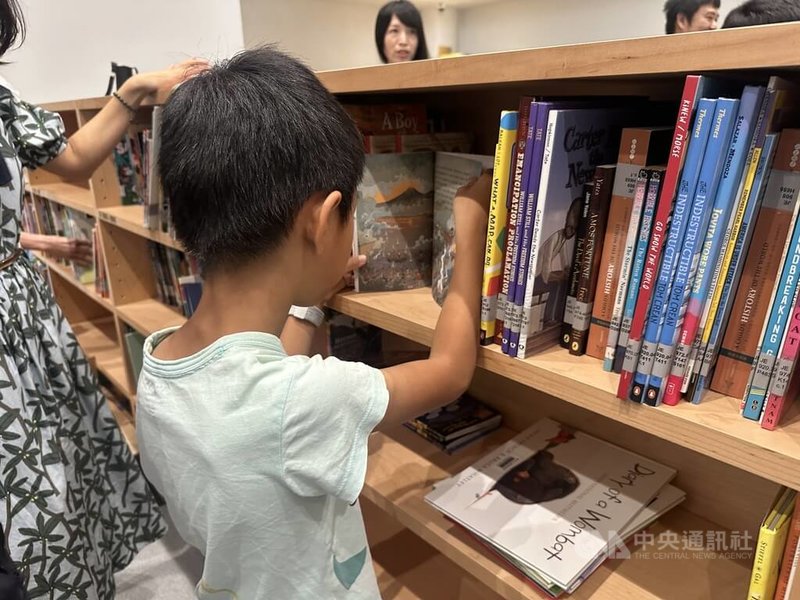 台中市綠美圖12月將正式開館,中市圖19日表示,新總館28日起至11月16日試營運,將率先開放兒童閱覽區、青少年閱覽區等空間。圖為小朋友19日在圖書上架活動中把握機會翻閱書籍。中央社記者趙麗妍攝 114年10月19日