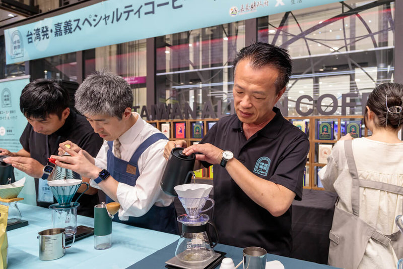 嘉義縣府與11家咖啡莊園業者即日起在日本大阪近鐵百貨設置專區,展售產自阿里山區的精選精品,18日縣長翁章梁(左3)在現場手沖咖啡,供日本消費者試飲。(嘉義縣政府提供)中央社記者蔡智明傳真 114年10月19日