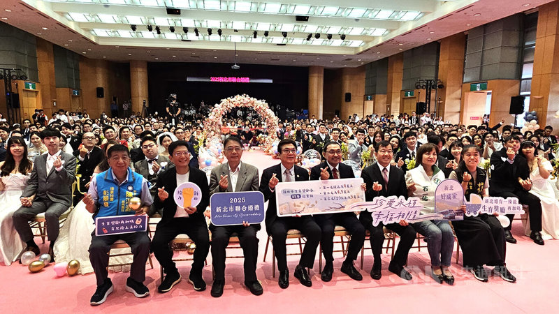 新北市政府2025年聯合婚禮19日溫馨登場,在新北市長侯友宜(前右4)、副市長劉和然(前左4)等人見證下,102對新人互許終身、共結連理。中央社記者王鴻國攝 114年10月19日