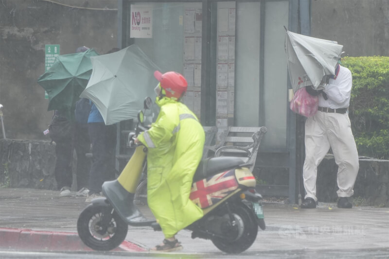 氣象署持續發布豪雨特報,東北季風及颱風風神外圍環流影響,20日台北市及新北市有局部豪雨或大豪雨。圖為民眾在台北市北投區遭強風吹拂,靠在公車站旁躲避。中央社記者徐肇昌攝 114年10月20日