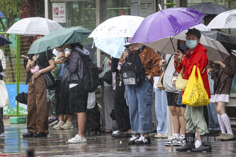 受到東北季風及颱風風神外圍環流影響,大台北地區21日白天雨勢不斷,台北市文山區有許多民眾撐著傘在雨中等待公車。中央社記者鄭清元攝 114年10月21日