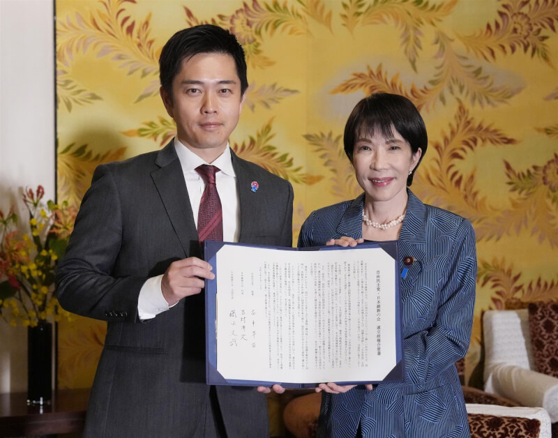 自民黨總裁高市早苗(右)和維新會代表吉村洋文(左)20日簽署聯合執政協議書。(共同社)
