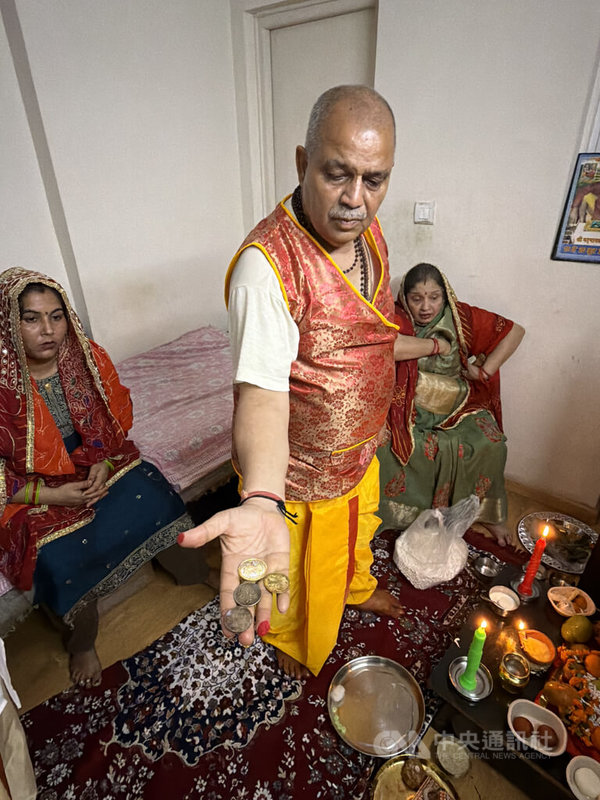 印度人排燈節(Diwali)祭祀(Puja)的「眉眉角角」很多,流程通常由家中男性長輩主導。圖為印度家庭男性長輩展示將擺上供桌的錢幣。中央社記者李晉緯新德里攝 114年10月21日