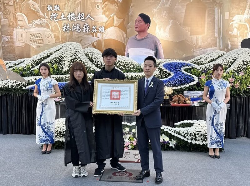 桃園市挖土機行老闆林鴻森赴花蓮救災時受傷,引發敗血症死亡。總統府副秘書長何志偉(前右)22日代表總統到家祭儀式上頒給褒揚令,表彰捨命救災義舉,由林鴻森的兒子、女兒代表接受。(家屬提供)中央社記者魯鋼駿傳真 114年10月22日