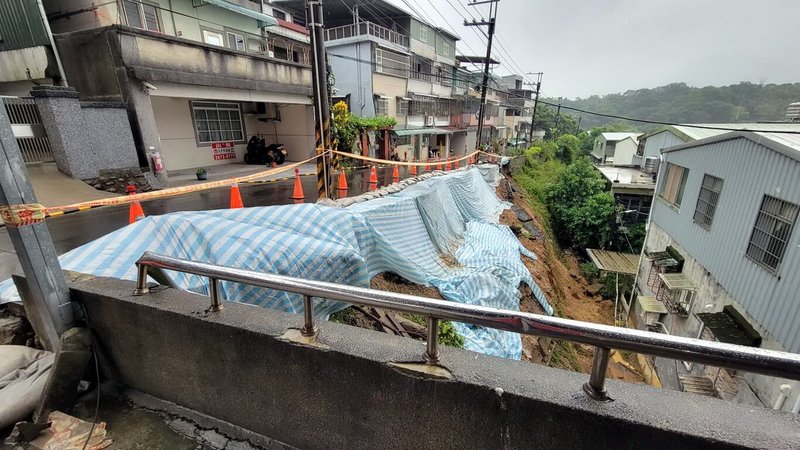 受東北季風及東邊低壓影響,迎風面的大台北地區、宜蘭山區降雨仍明顯且持續,新北市三峽區二鬮路22日發生邊坡土石滑落,已經暫時鋪上帆布,設封鎖警示。(三峽區公所提供)中央社記者黃旭昇傳真 114年10月22日