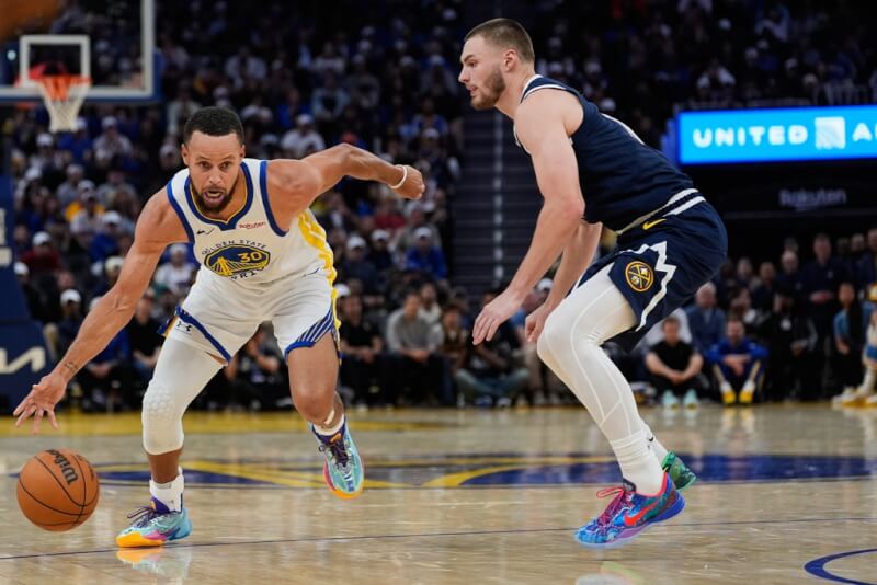 NBA金州勇士球星柯瑞(左)24日個人獨得42分,並在正規賽尾聲投進追平比分的關鍵三分球,助球隊以137比131擊敗丹佛金塊。(美聯社)