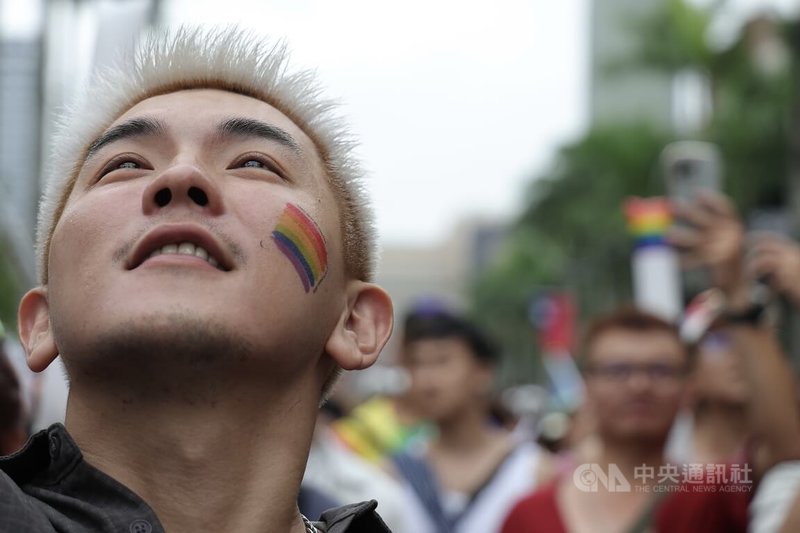 2025第23屆台灣同志遊行25日下午在台北盛大登場,吸引大批人潮響應參與,有民眾在臉頰貼上彩虹旗紋身貼紙,呼籲社會跨越由偏見、恐懼所築起的標籤,打造真正平等多元的國度。中央社記者翁睿坤攝 114年10月25日