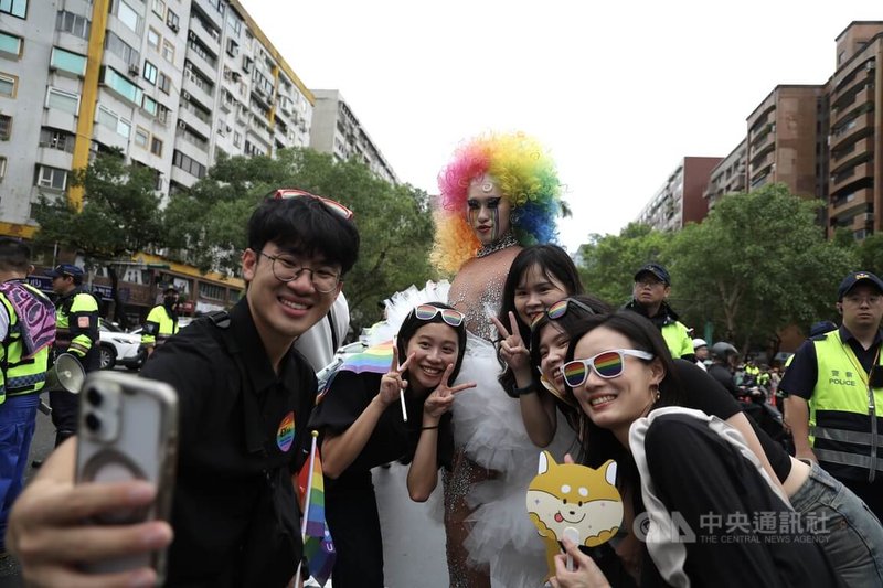 2025台灣同志遊行25日下午在台北進行,現場民眾裝扮華麗戴著彩虹假髮與其他民眾一同自拍留念。中央社記者翁睿坤攝 114年10月25日