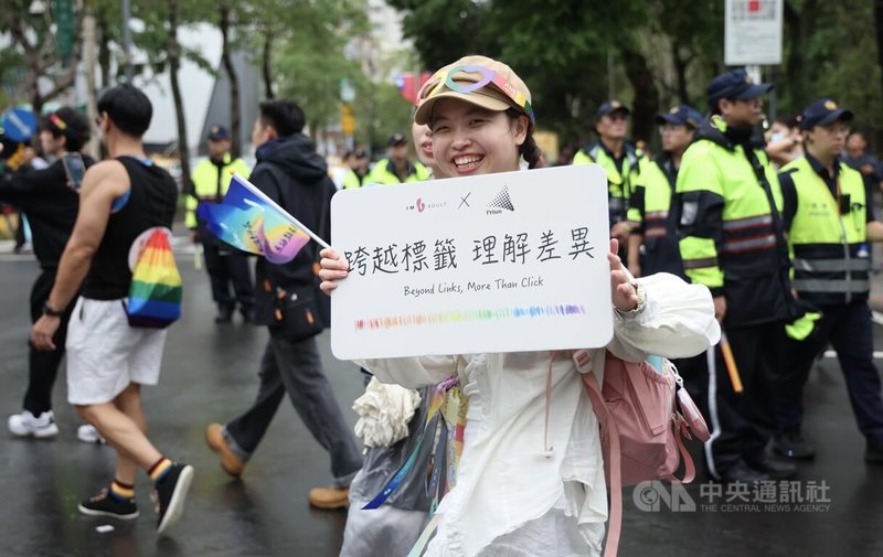 2025第23屆台灣同志遊行25日下午在台北市政府前廣場正式登場,主辦單位預估約有13萬人參與,今年主題為「超.連結-跨越標籤,理解差異」,參與民眾開心秀出手中標語。中央社記者張新偉攝 114年10月25日