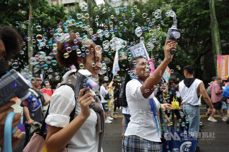 同志遊行在台北市議會前集結登場,現場也有不少外籍人士響應參與,手持泡泡槍開心享受遊行氣氛。中央社記者翁睿坤攝 114年10月25日