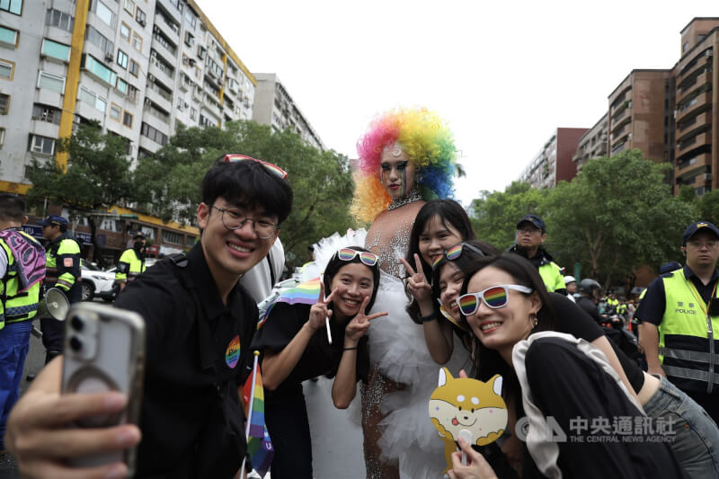 民眾裝扮華麗戴著彩虹假髮與其他民眾一同自拍留念。中央社記者翁睿坤攝 114年10月25日