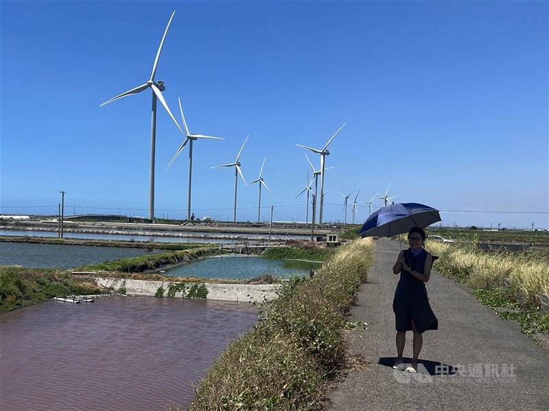 圖為民眾在彰化芳苑風力發動機前留影。 （中央社檔案照片）