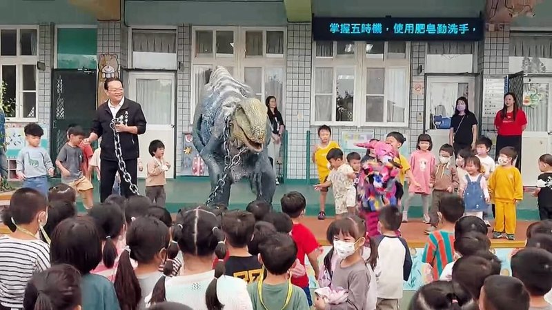 馬公市公所辦理萬聖節系列活動,「缺席舞團」27日帶著一隻仿真的恐龍,走進馬公市立幼兒園近距離與小朋友互動,引起幼兒們一陣驚叫與驚喜,令小朋友個個印象深刻。(馬公市公所提供)中央社 114年10月27日