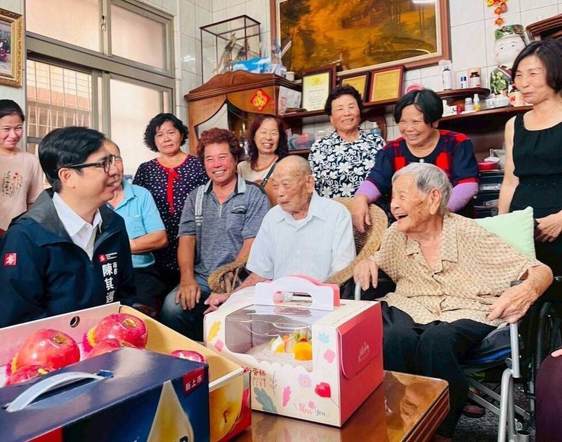 高雄市長陳其邁(前排左1)27日赴田寮區慰訪百歲人瑞夫妻,各致贈新台幣1萬元重陽敬老禮金,並代表衛生福利部頒贈金鎖片,祝福兩人健康長壽。(高雄市政府社會局提供)中央社記者張已亷傳真 114年10月27日