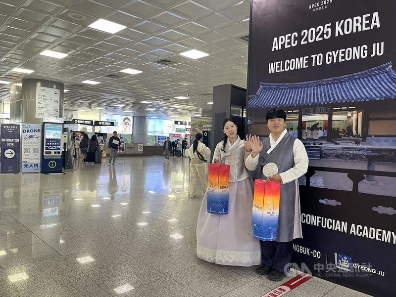 韓國釜山金海國際機場大廳可看到多名穿著韓國傳統服飾的迎賓人員,手提APEC字樣的燈籠。中央社記者潘姿羽攝  114年10月28日