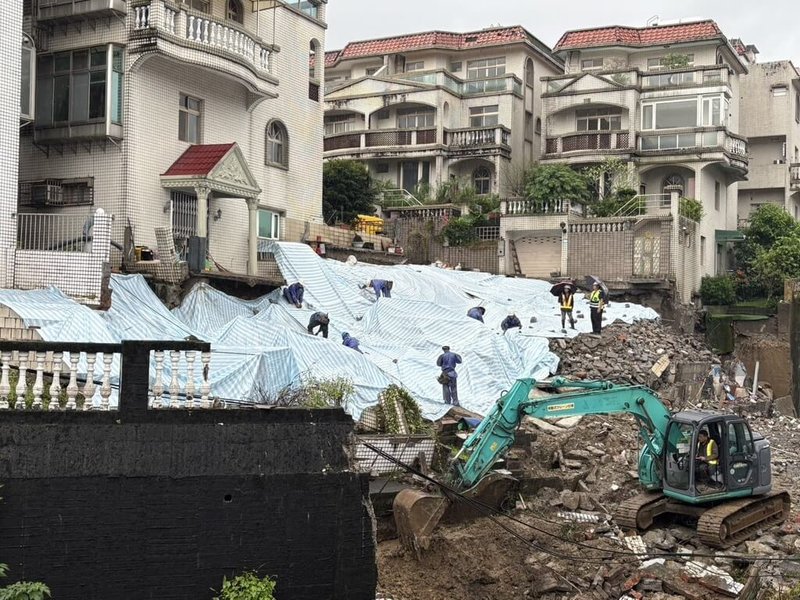 新北市新店錦繡、碧瑤社區間擋土牆日前坍塌,連日大雨未歇,28日清晨擴大預防性撤離4戶19人。工務局28日調派人力與機具持續進行降土壓清坡作業,人員到場覆蓋帆布加速搶災。(新北市工務局提供)中央社記者曹亞沿傳真 114年10月28日