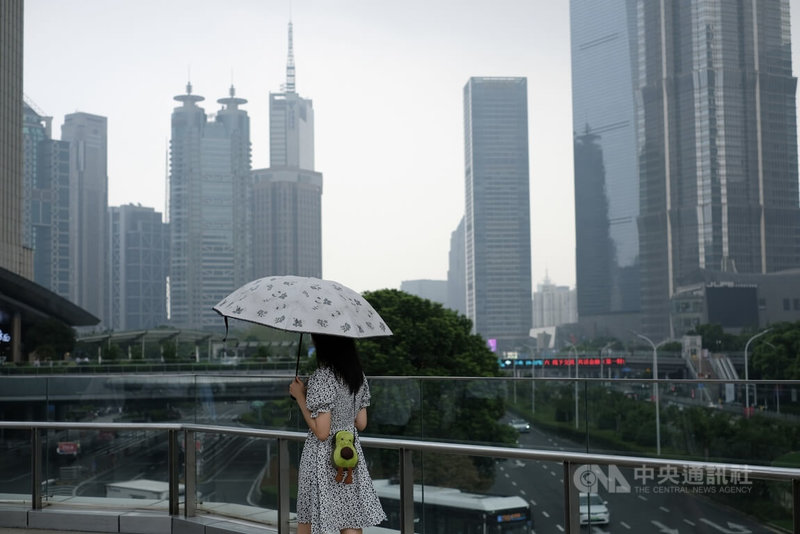 中國近年經濟下行,就業環境也越發嚴峻,民營企業內捲嚴重,加班成為常態。圖為上海陸家嘴天橋上撐傘的路人,攝於10月13日。中央社記者廖文綺上海攝 114年10月28日