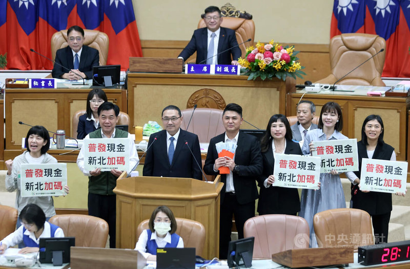 新北市議會28日進行市政總質詢,民進黨團要求市府在中央普發現金新台幣1萬元時,加碼市民每人4.6萬元;市長侯友宜(立者左3)表示,市府債都還沒還完,要如何發現金,這說不過去。中央社記者王鴻國攝 114年10月28日