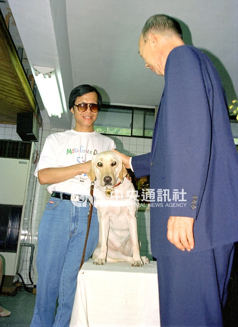 盲人重建院院長曾文雄(右)為國內第一隻導盲犬「雅琪」佩戴證明頸勛。中央社記者黃旭昇攝 85年11月1日