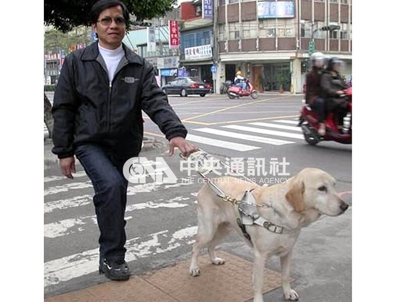 台灣盲人重建院教務主任柯明期握著導盲鞍,依靠雅琪判斷路況。中央社記者黃旭昇攝 92年6月5日