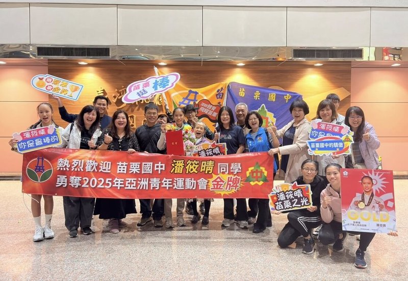 苗栗縣苗栗國中學生潘筱晴(前左5)在2025巴林亞洲青年運動會勇奪跆拳道女子個人自由品勢金牌,28日晚間載譽歸國,親友團與師長熱情接機。(苗栗國中提供)中央社記者管瑞平傳真 114年10月29日