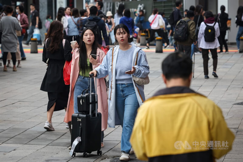 圖為民眾穿著外套在台北西門商圈逛街。(中央社檔案照片)