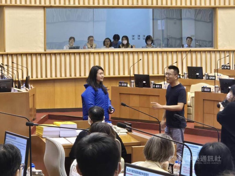 國民黨屏東縣議員黃明賢（中右）關心熱傷害職災案大幅成長，30日議會質詢時，現場拿出一件風扇衣，請縣府勞動暨青年發展處長李雨蓁（中左）試穿，李雨蓁表示降溫有感。中央社記者黃郁菁攝　114年10月30日