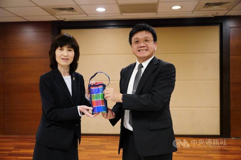 日本福岡雙葉中學師生30日到新竹市光復高中交流,光復高中校長李詩慶(右)贈送在地環保飲料袋「茄芷袋」給日方。中央社記者郭宣彣攝 114年10月30日