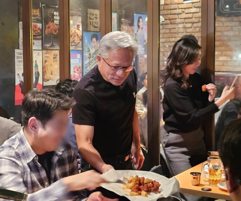 NVIDIA執行長黃仁勳31日在首爾餐廳大啖炸雞配啤酒,並與店內客人分享炸雞。(韓聯社)