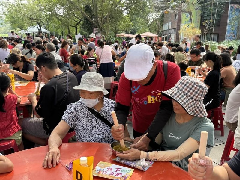 2025六堆秋收祭1日開幕，開幕活動「千人共下打粢粑」，民眾手持木棍，將糯米搗成一整團粢粑，一起體驗客家米食文化。中央社記者李卉婷攝 114年11月1日