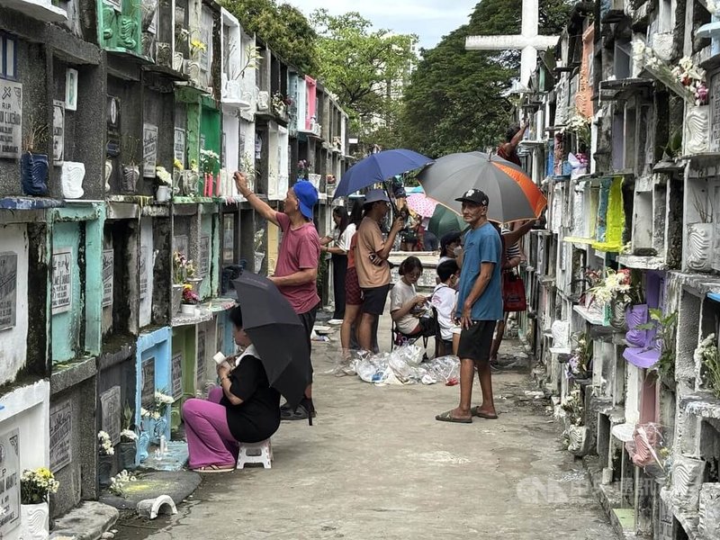 菲律賓民眾每年在11月1日的「萬聖節」和11月2日的「萬靈節」掃墓。圖為馬尼拉南墓園內，民眾追思逝去的親人。中央社記者林行健馬尼拉攝 114年11月1日