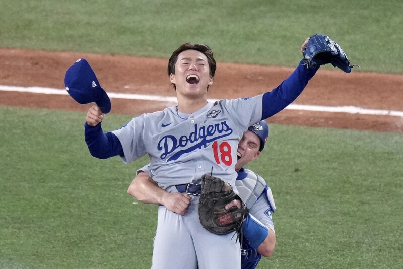 MLB洛杉磯道奇日籍強投山本由伸（前）1日力繳2.2局完美壓制對手，賽後他被捕手史密斯抱起慶祝勝利。（Chris Young/The Canadian Press via 美聯社）