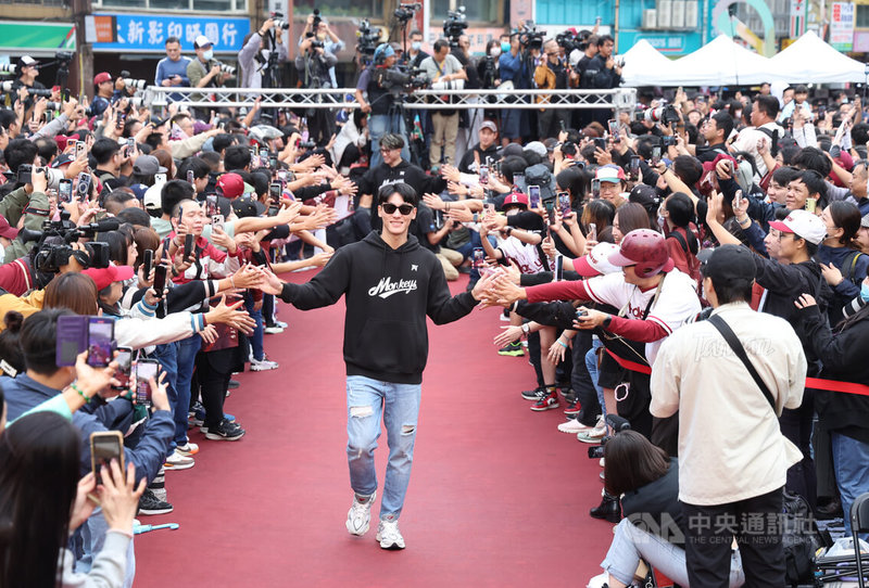中華職棒樂天桃猿封王遊行2日盛大登場,下午抵達終點站桃園市政府廣場,球員陳晨威(前中)走上紅毯,與球迷擊掌致意。中央社記者張新偉攝 114年11月2日