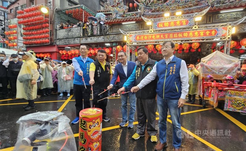 新北市舉辦「慈惠宮、拱天宮百年會香」活動,市長侯友宜(左3)及板橋慈惠宮主委賴春穆(左2)、苗栗白沙屯拱天宮主委洪文華(右2),一同點燃起馬炮,冒雨展開祈福踩街活動。中央社記者王鴻國攝 114年11月2日