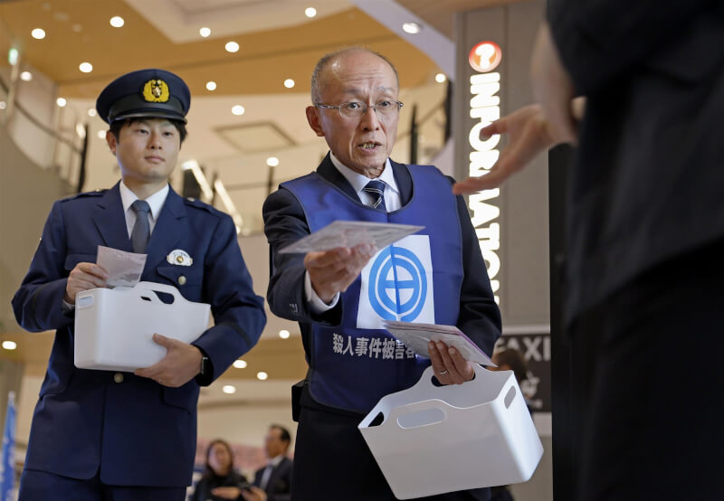 圖為2024年11月高羽悟(右)在名古屋市派發傳單,呼籲大眾提供相關線索。(共同社)