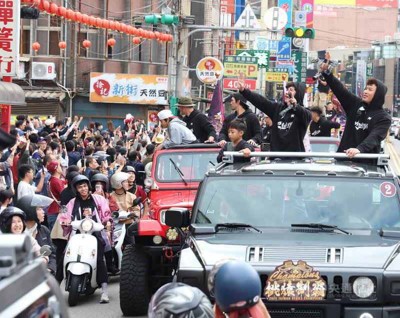 中華職棒樂天桃猿封王遊行2日下午登場,路線從樂天桃園棒球場出發,一路至桃園市政府廣場,球員林泓育(車上右起)、林立向球迷揮手致意,一同歡慶奪冠喜悅。中央社記者張新偉攝 114年11月2日