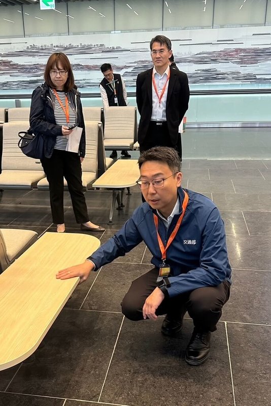交通部長陳世凱(前)3日前往視察桃園國際機場第3航廈北登機廊廳整備作業,特別蹲下檢視連座椅邊桌情況。(桃園國際機場公司提供)中央社記者吳睿騏桃園機場傳真 114年11月3日