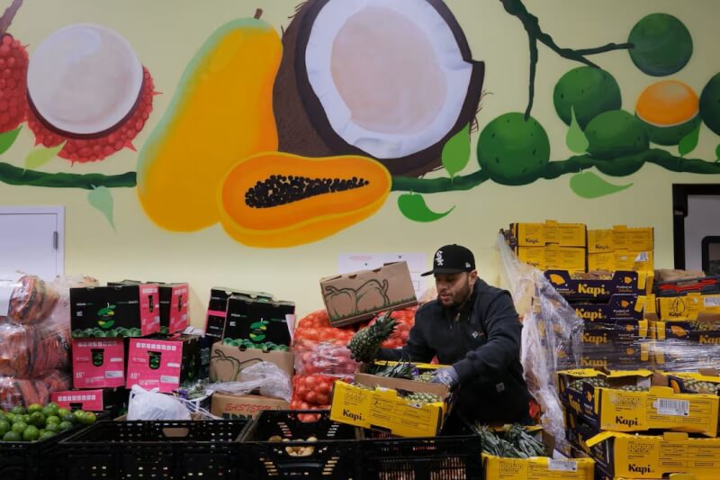 圖為10月29日美國麻薩諸塞州一處食品救濟中心分揀蔬果的員工。（路透社）