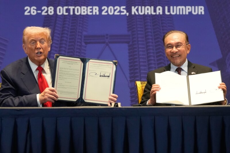 美國總統川普（左）與馬來西亞首相安華（右）10月26日在吉隆坡簽署貿易協議。（美聯社）