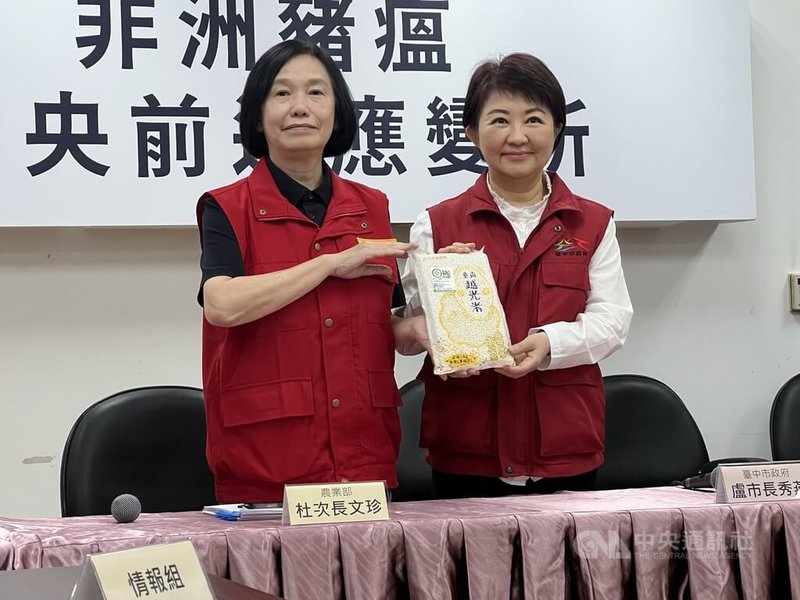 非洲豬瘟中央前進應變所6日舉行最後一場記者會，農業部次長杜文珍（左）送台南市越光米給台中市長盧秀燕（右），意喻病毒「清光光」。中央社記者郝雪卿攝   114年11月6日
