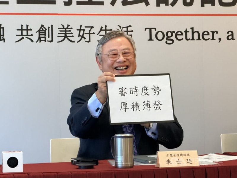 面對媒體追問是否有意併購壽險，永豐金總經理朱士廷（圖）6日出席第3季法說會會前記者會時，拿起手舉牌「審時度勢，厚積薄發」回應提問。中央社記者呂晏慈攝　114年11月6日