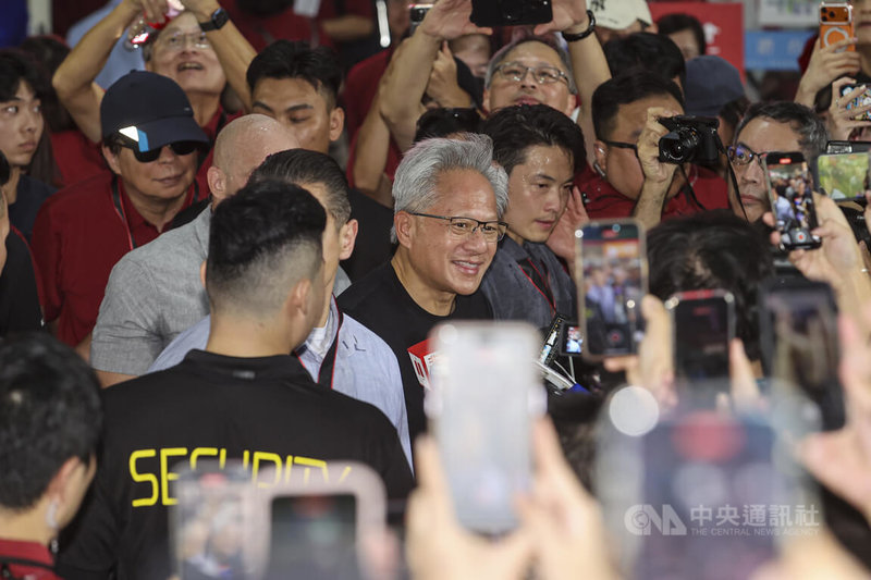輝達（NVIDIA）執行長黃仁勳（中）8日現身2025年台積電運動會，離去前接受媒體聯訪，並跟粉絲互動簽名。中央社記者鄭清元攝　114年11月8日