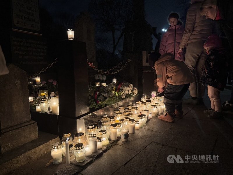 立陶宛萬聖節期間的墓園一點都不可怕，反而給人一種寧靜與溫暖的感覺。一位小男孩帶著長型打火機，在爸媽的陪同下穿梭在墓碑間，四處尋找熄滅的蠟燭，幫忙重新點燃。中央社記者游堯茹維爾紐斯攝　114年11月9日