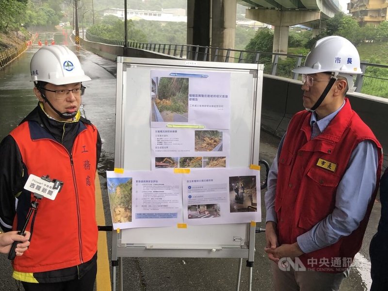 基隆市暖暖區興隆街一處邊坡崩塌，路面土石已清除，市長謝國樑（右）10日下午前往現場，聽取工務處長簡翊哲（左）簡報邊坡處理情形。中央社記者王朝鈺攝　114年11月10日
