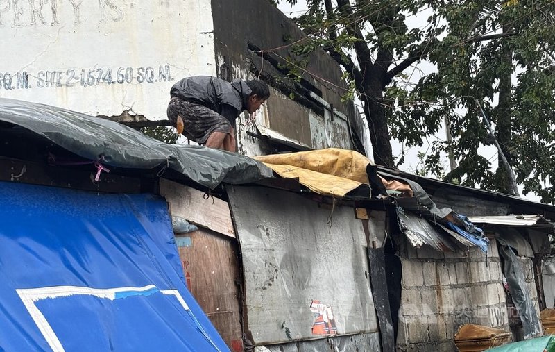 颱風「鳳凰」重創菲律賓北部的呂宋島,大馬尼拉地區也有災情。圖為馬尼拉市居民趁風雨稍歇修理屋頂。中央社記者林行健馬尼拉攝 114年11月10日